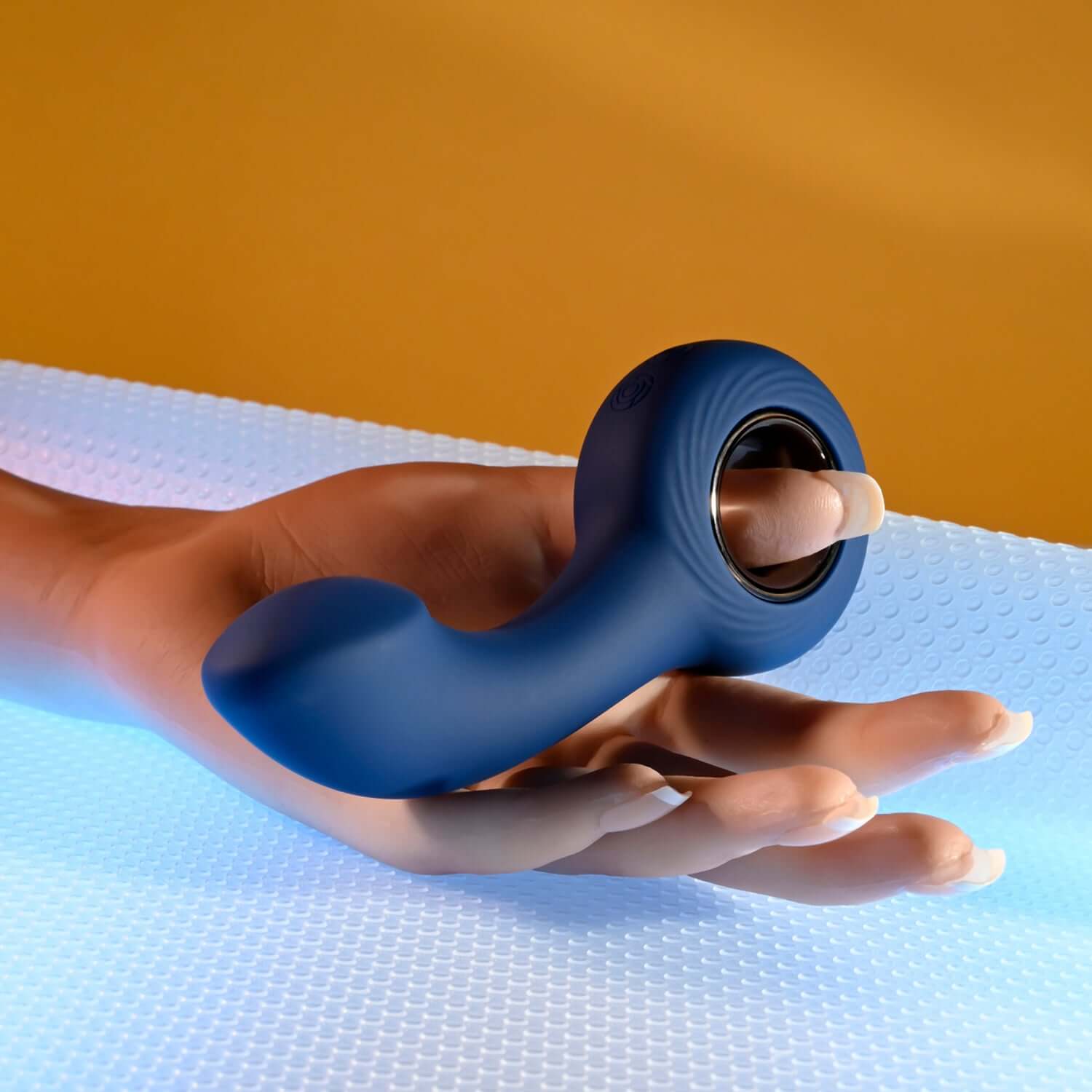 Blue anal vibrator held in a hand, featuring a curved shaft and ringed handle for comfort and control.