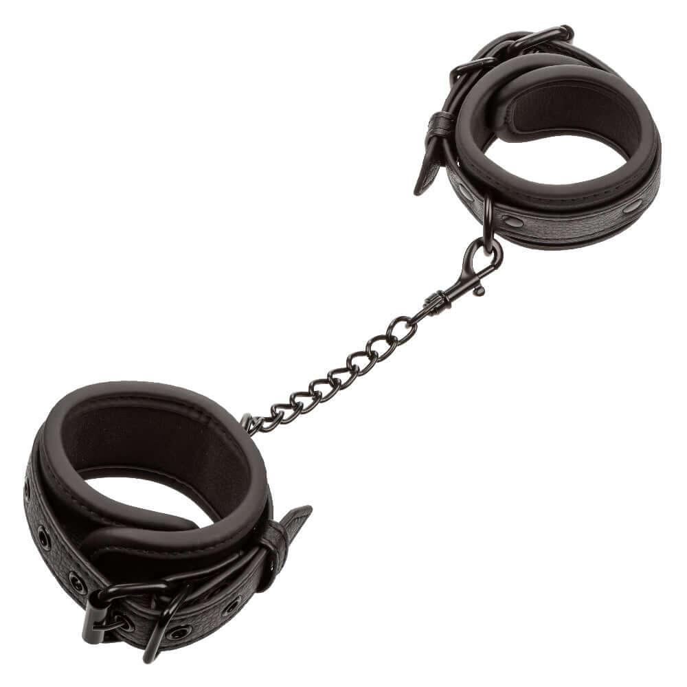 Adjustable black wrist cuffs with buckle closure and metal chain from the Nocturnal Collection.