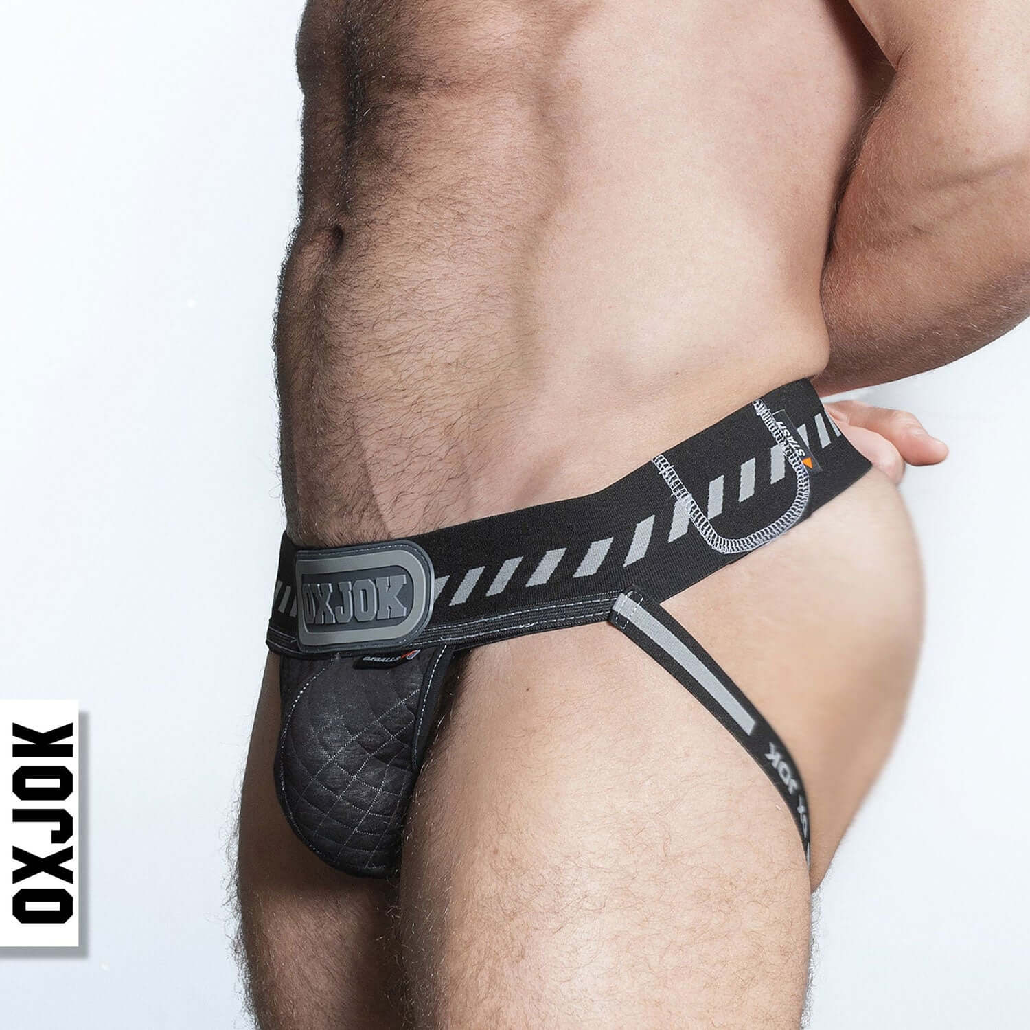 Man wearing Packer Industrial Quilted Cargo Strapjock in Black Puff Small with hazard stripe waistband and 3-D rubber oxjock label.