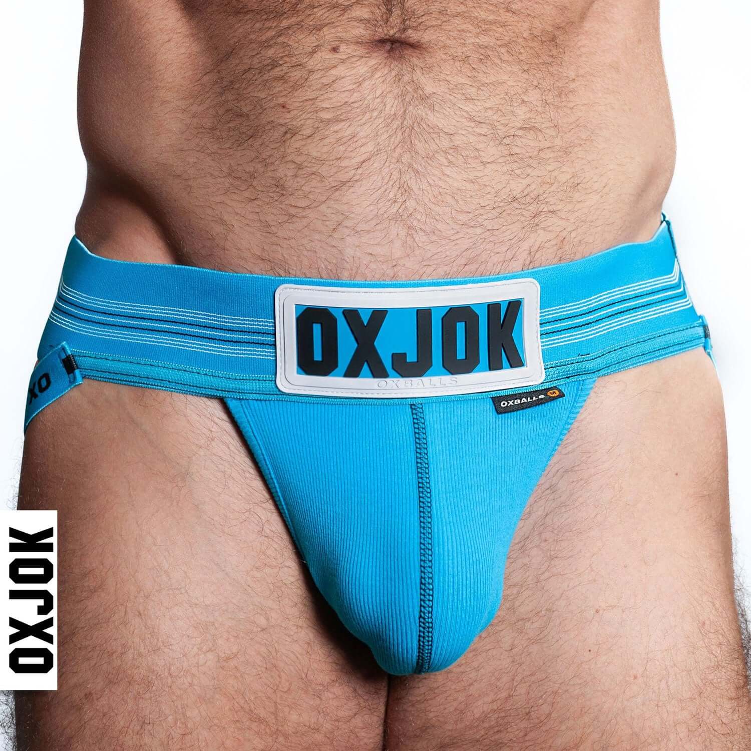 Close-up of man wearing blue Oxjok Slingjock Upthrust Slider-Strap Jock with logo and adjustable waistband.