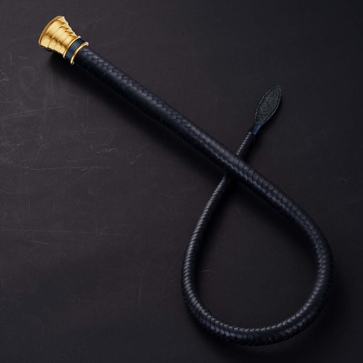 UPKO Black Label Collection Whip featuring black Italian leather and a gold handle, symbolizing luxury and intimacy.