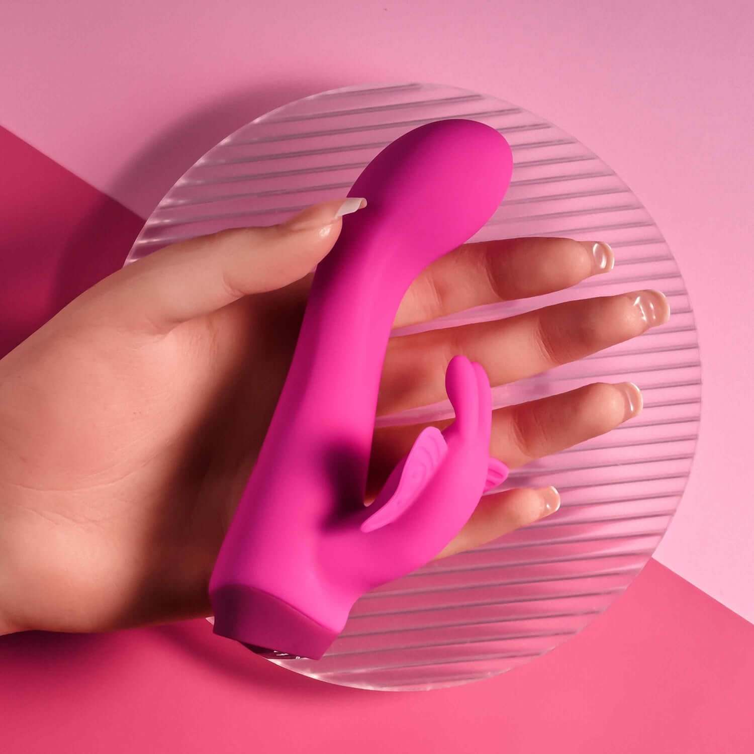 Pink Butterfly Love Rabbit Vibrator held in hand, showcasing its curved shaft and butterfly stimulator on a pink background.