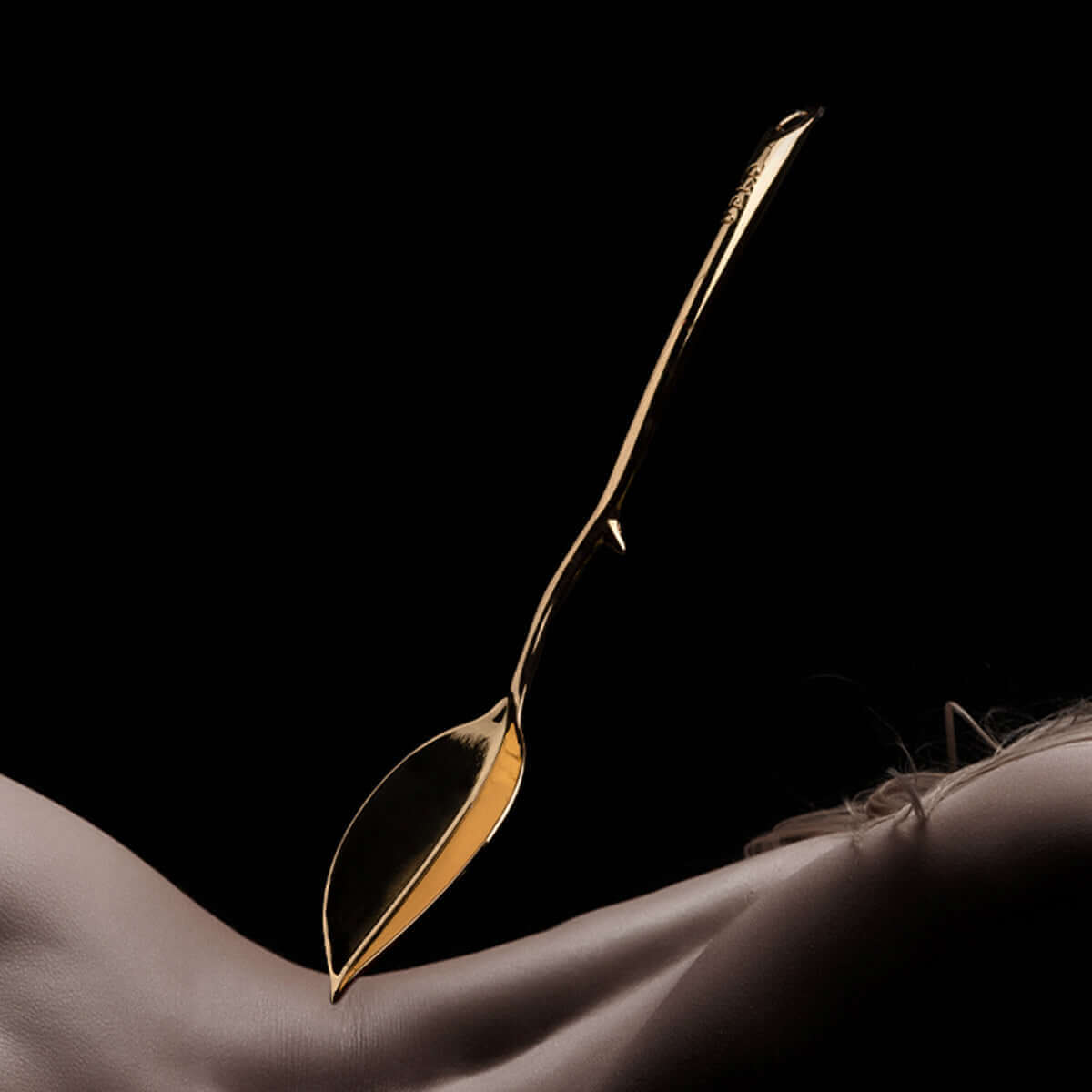 UPKO Candle Wax Scraper gliding over skin, showcasing its stylish design for sensual wax play.