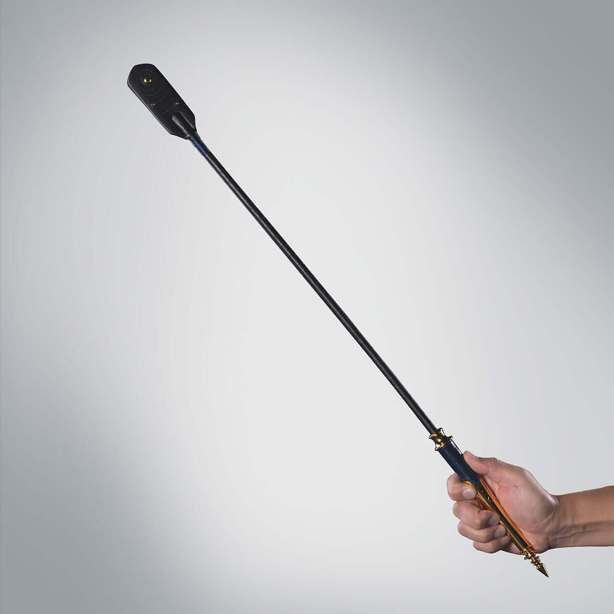 UPKO Black Label Collection Riding Crop held elegantly, showcasing luxury Italian leather and gold detailing.