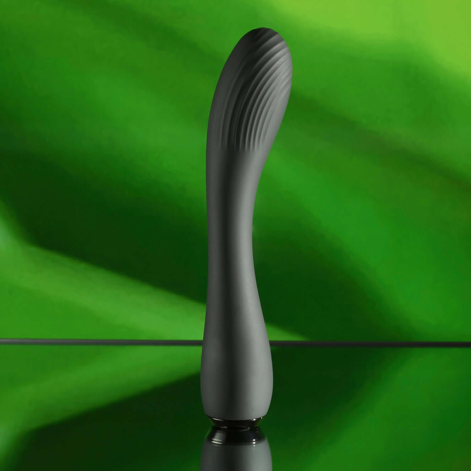 Midnight Magic G-spot vibrator in black, featuring a curved design, textured shaft, and elegant base against a green background.