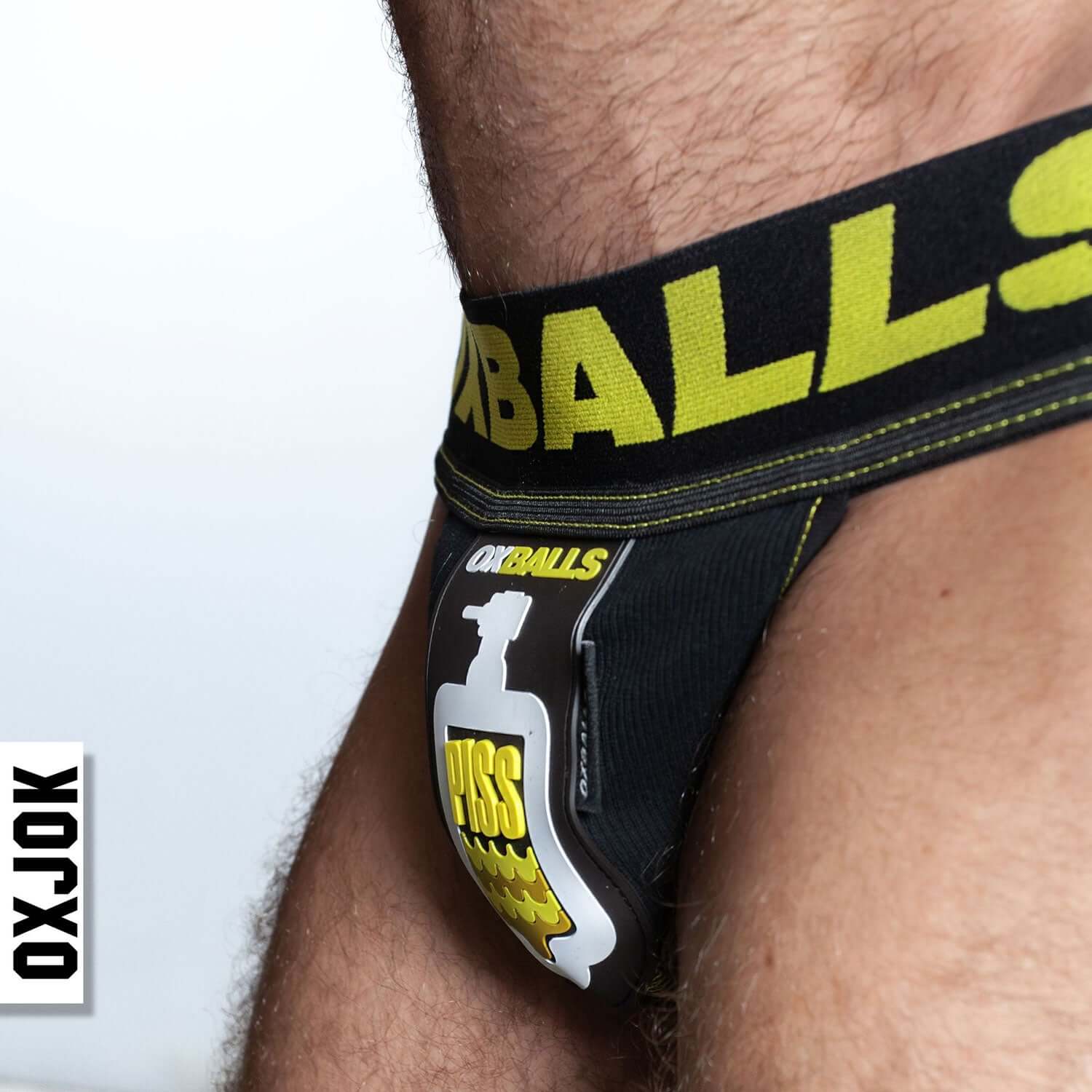 Oxjok Pisspig 3D Rubber Urinal Patch Pouch in black and yellow jockstrap with embroidered waistband for watersport lovers.