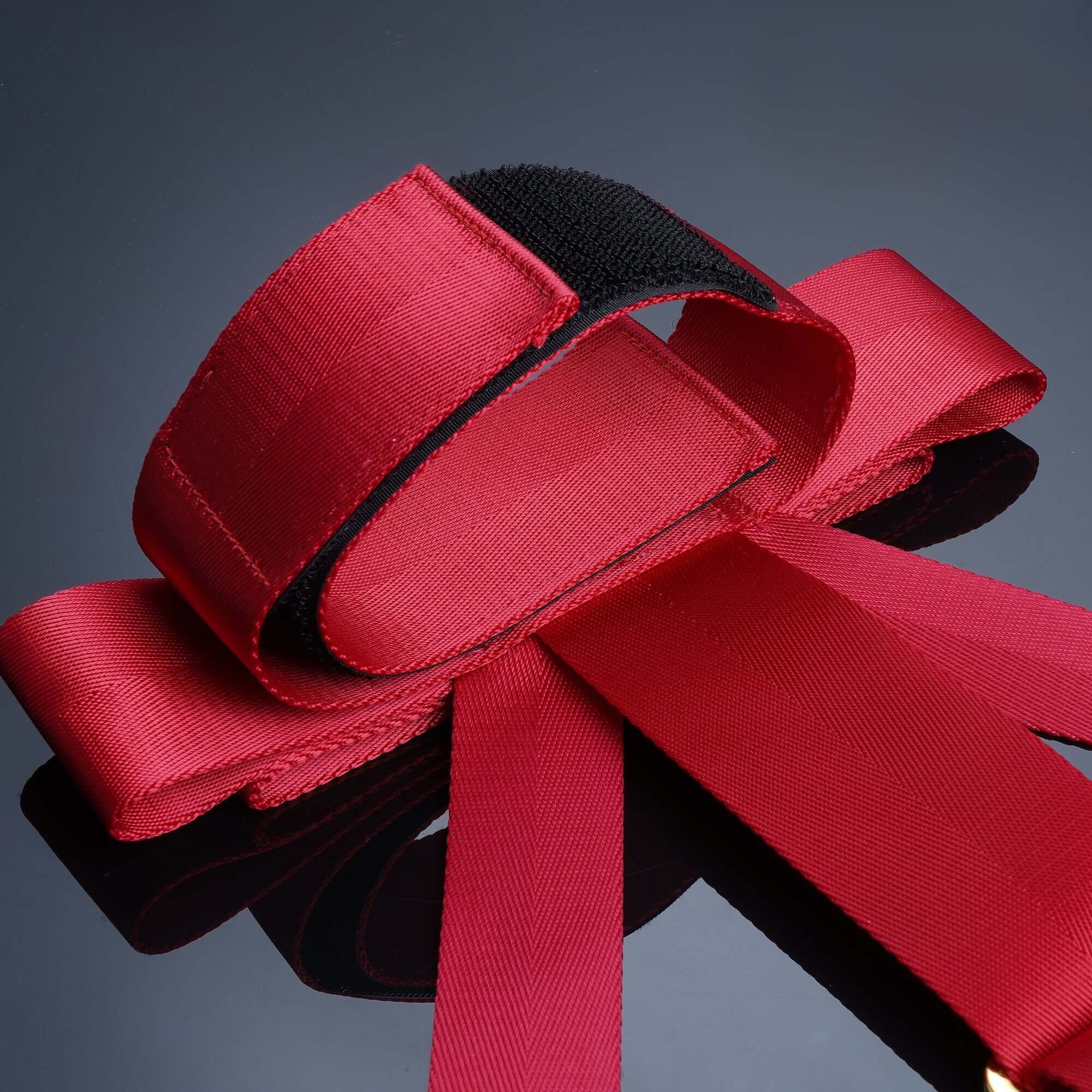 Red satin bowknot bed restraint straps, designed for playful bondage and intimate experiences.