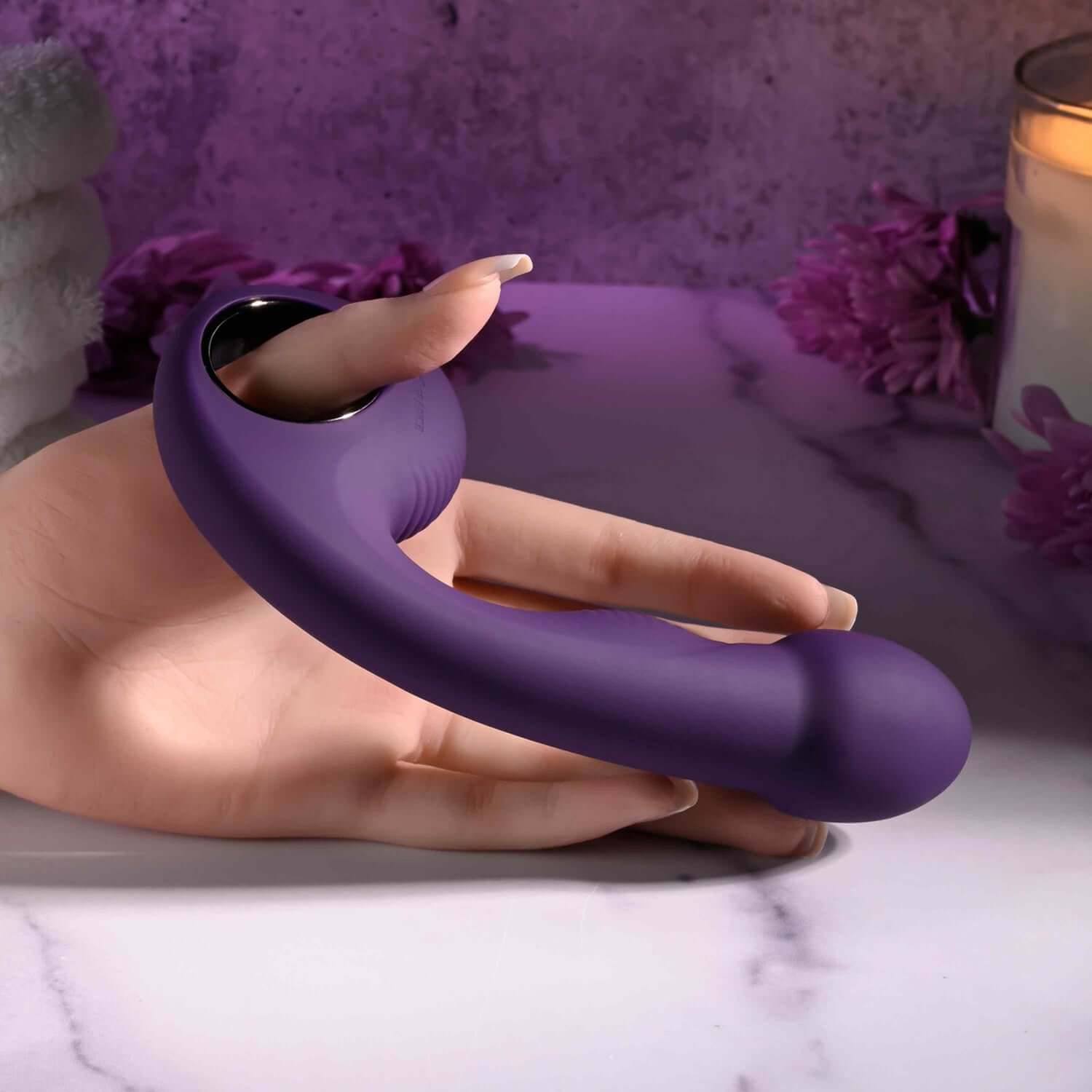 Purple rechargeable vibrator held in a hand, featuring a textured handle and bulbous head for comfort and pleasure.