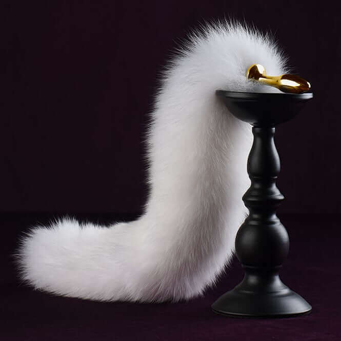 White fox fur tail small butt plug on a black pedestal, showcasing its luxurious design and 24K gold-plated metal details.