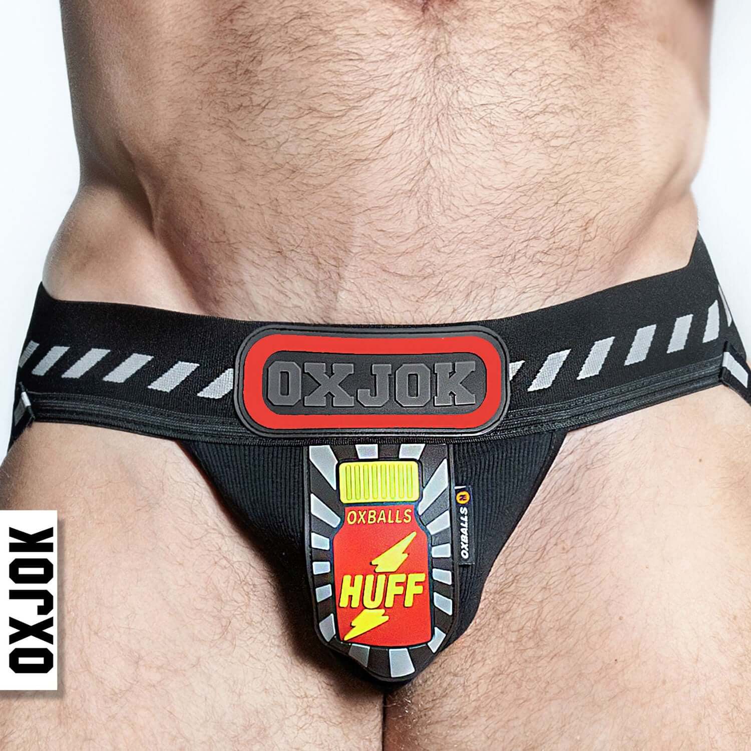 Man wearing Oxjok Pjock 3D Rubber Patch Jockstrap with black and red XL pouch for maximum comfort and storage.