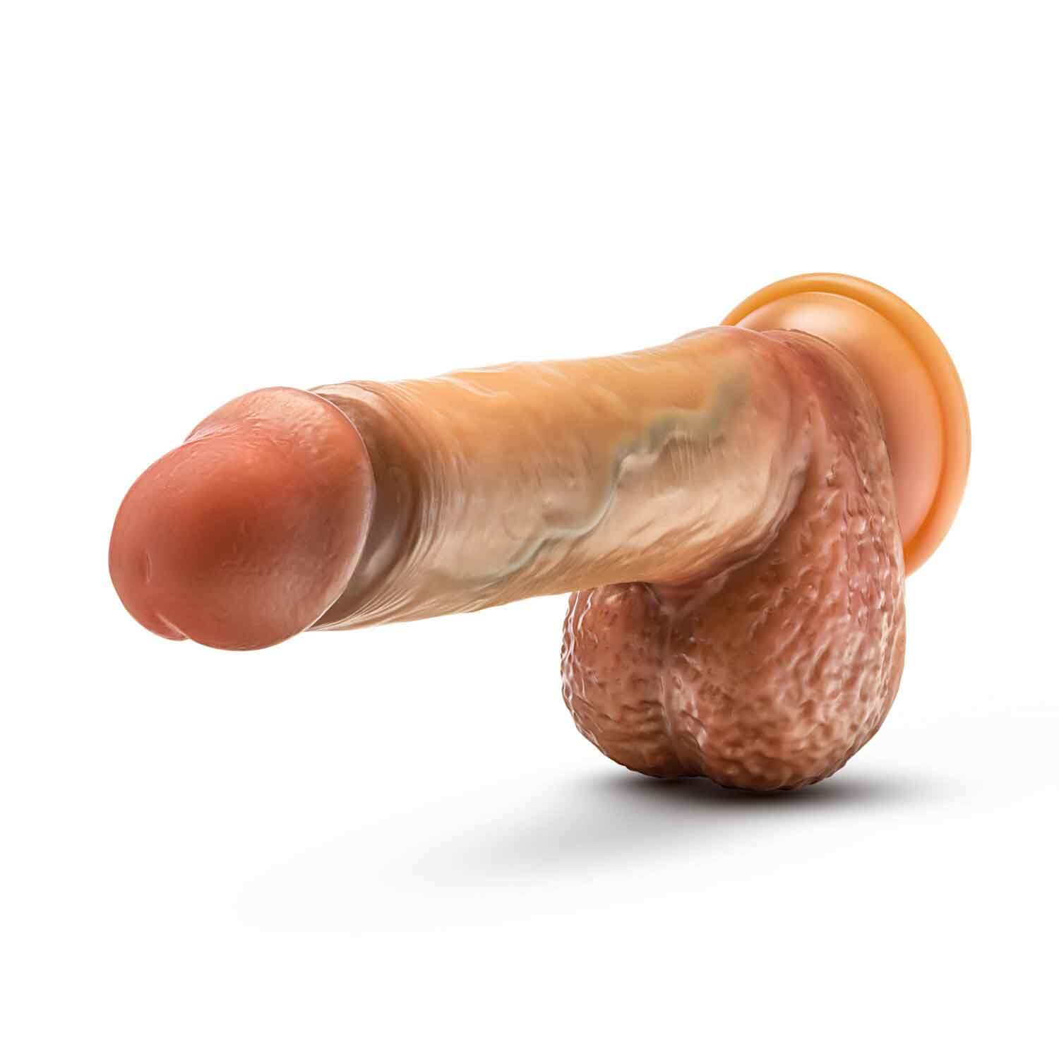 9.5 inch realistic sliding foreskin dildo with squeezable balls in tan color, featuring dual density technology and Purio liquid silicone outer layer.