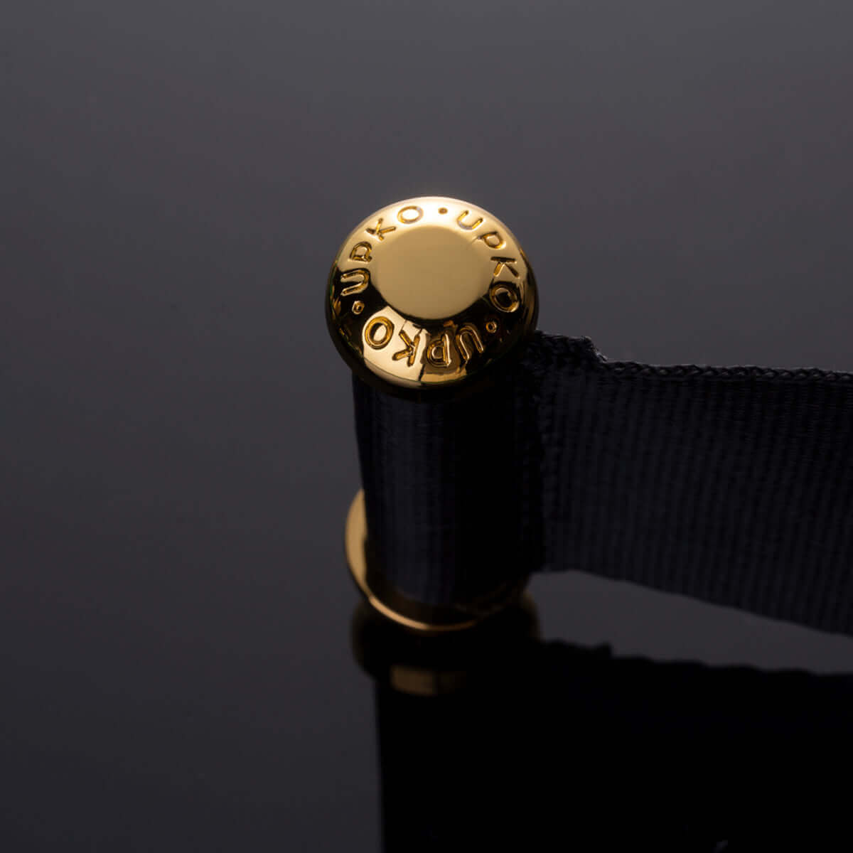 UPKO gold button detail on over-the-door hand restraint strap, showcasing high-quality alloy and nylon materials.