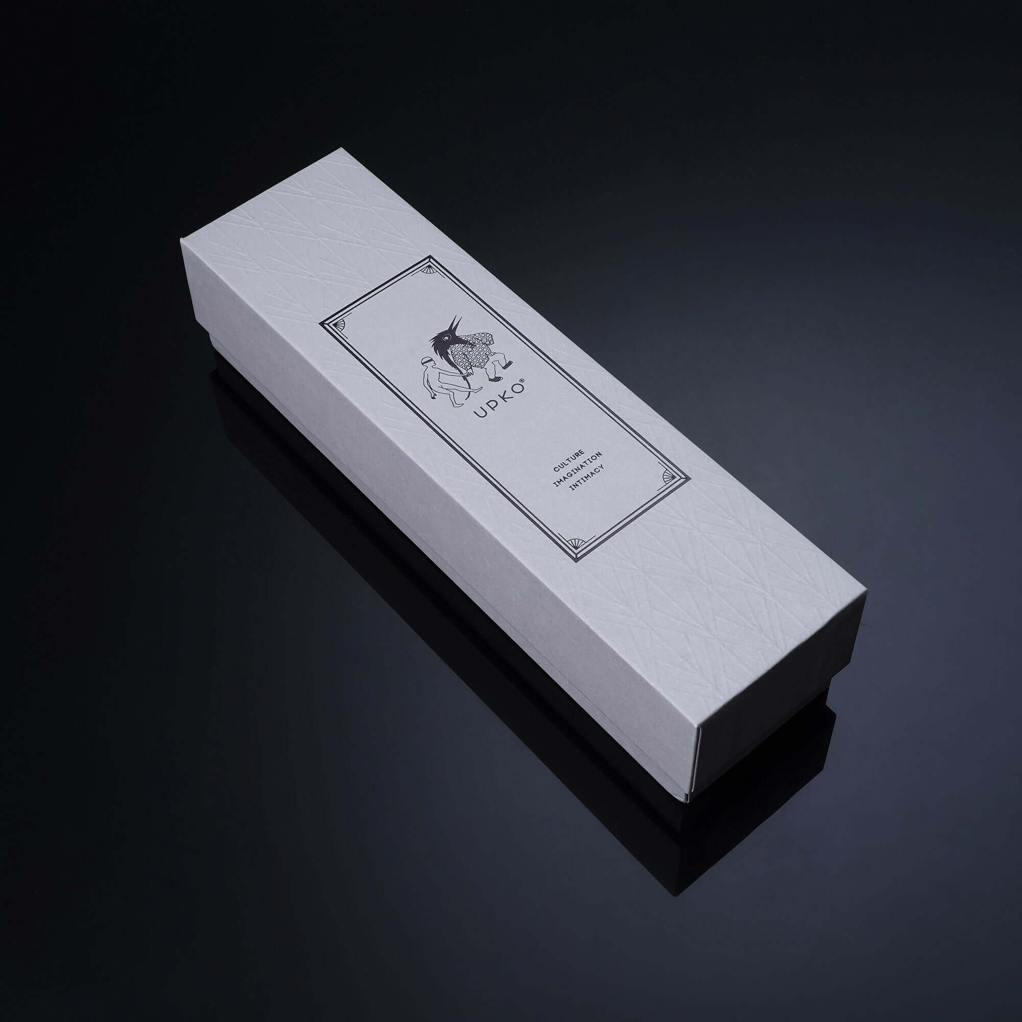 Elegant white packaging box for UPKO Knot-Shaped Mouth Gag with stylish design on a dark background.