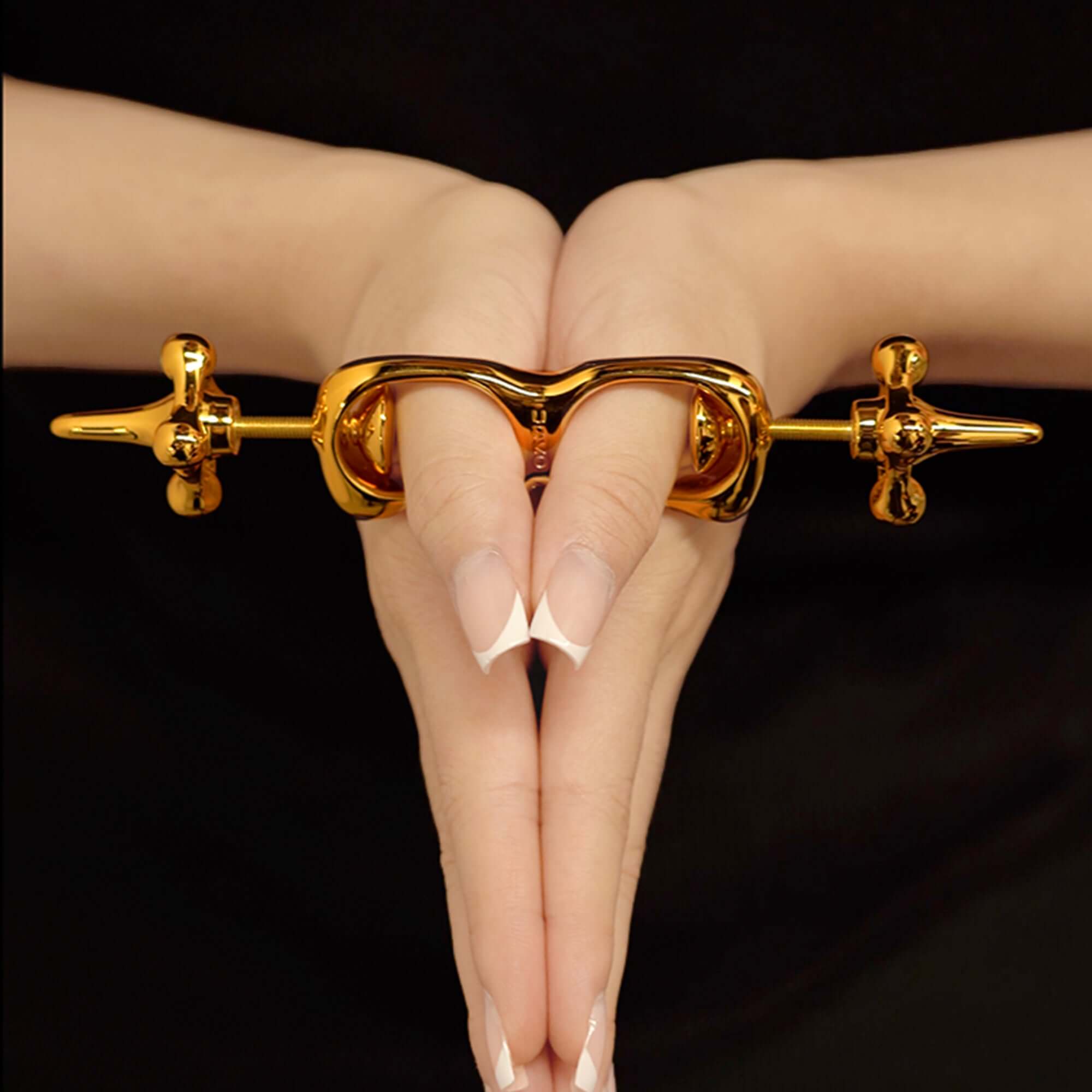 UPKO Thumb Metal Cuffs securely clasping fingers together, showcasing a sleek gold design for discipline play.