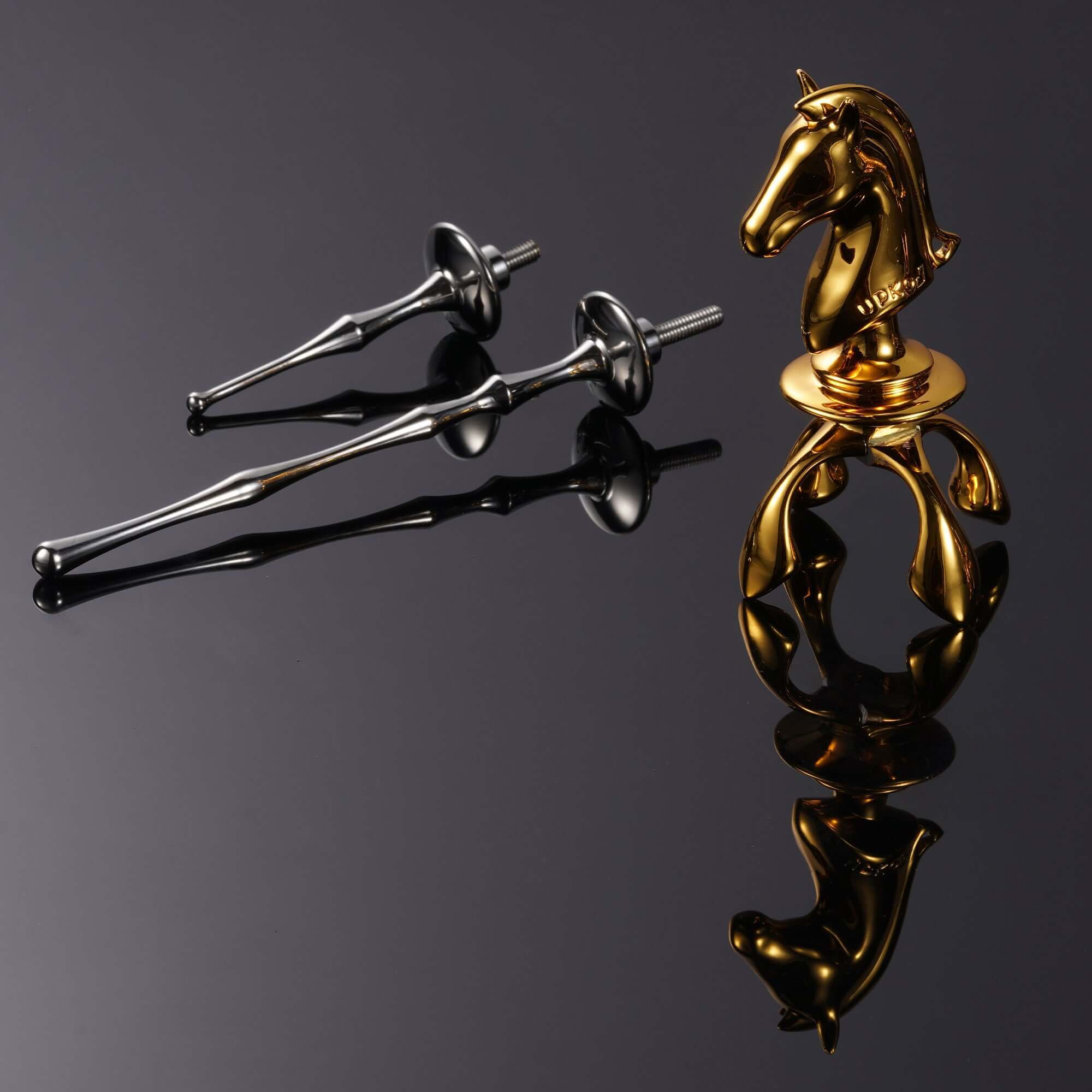 Two-tone Knight Urethral Sound set with gold horse figurine on a reflective surface.