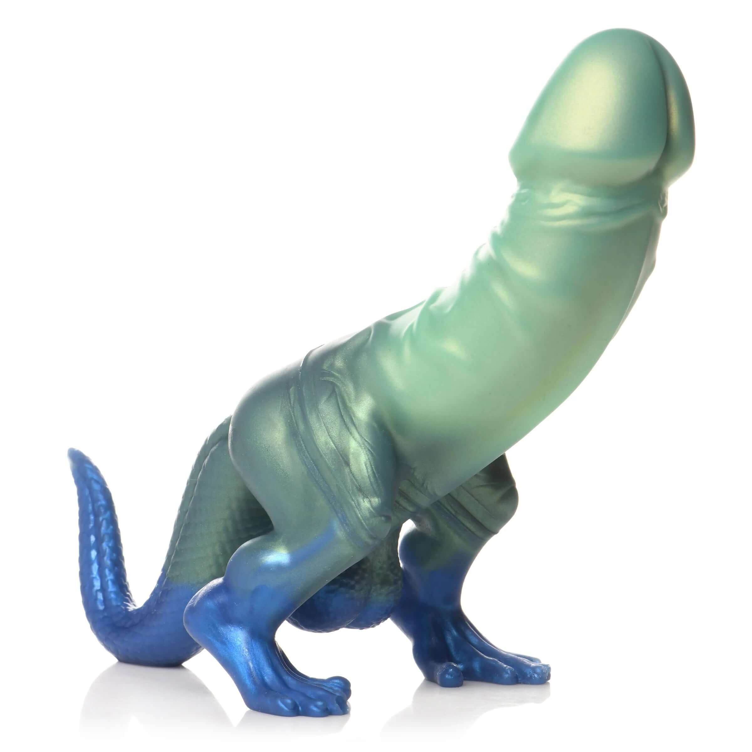 Green and blue silicone dinosaur dildo with a glittery finish, featuring a veined shaft, mushroom head, dinosaur legs, curved tail, and small balls.