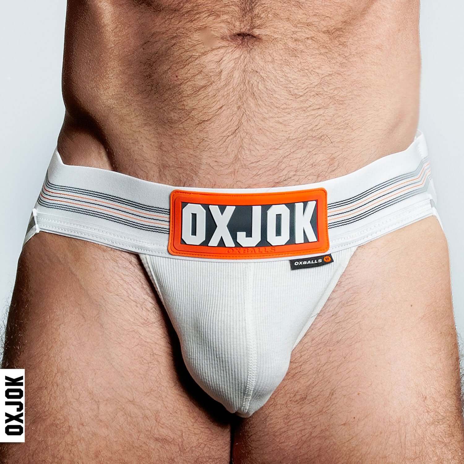 Man wearing Oxjok white Slingjock Upthrust Slider-Strap Jock with ribbed pouch and sturdy straps for comfort and support.