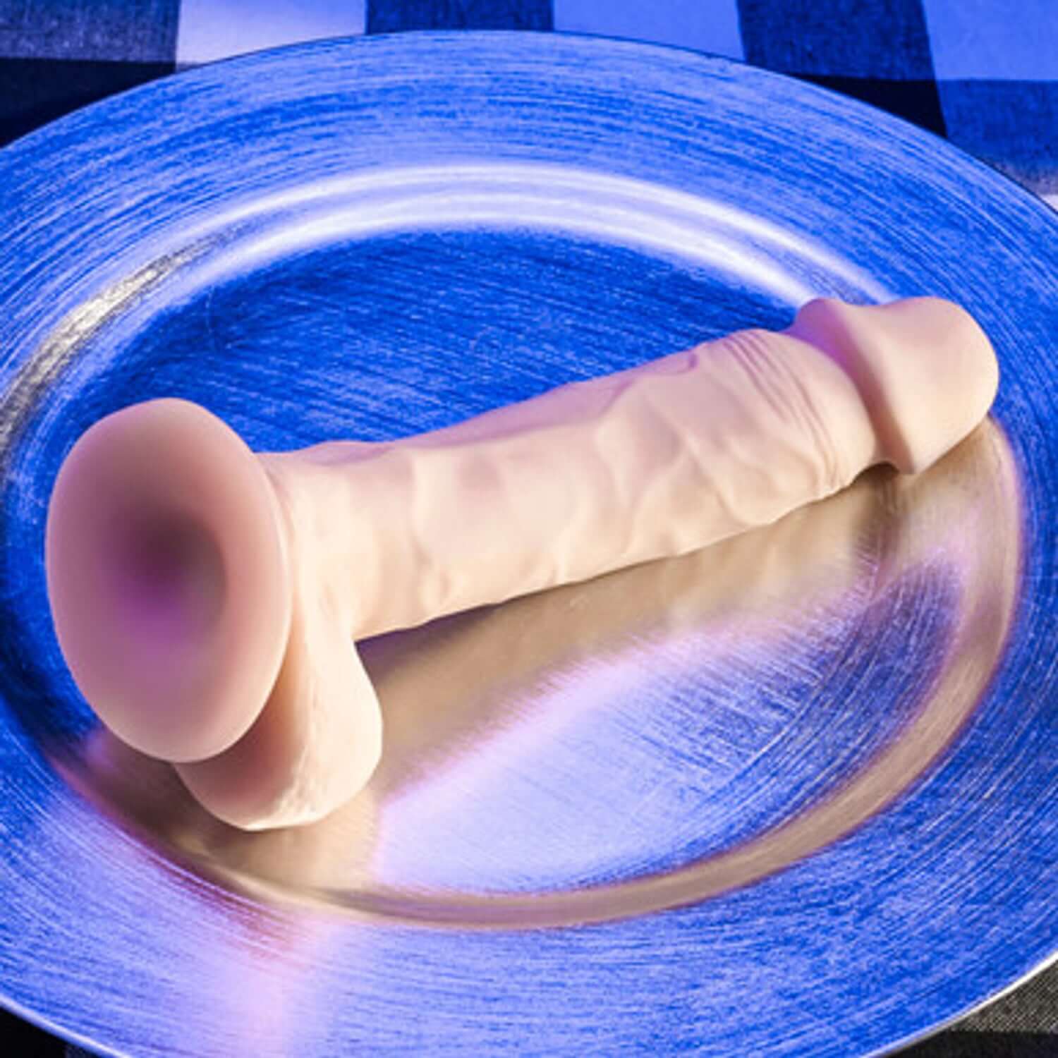 Realistic 6.5-inch natural feel dildo on a silver plate, showcasing flexible shaft and strong suction cup base.