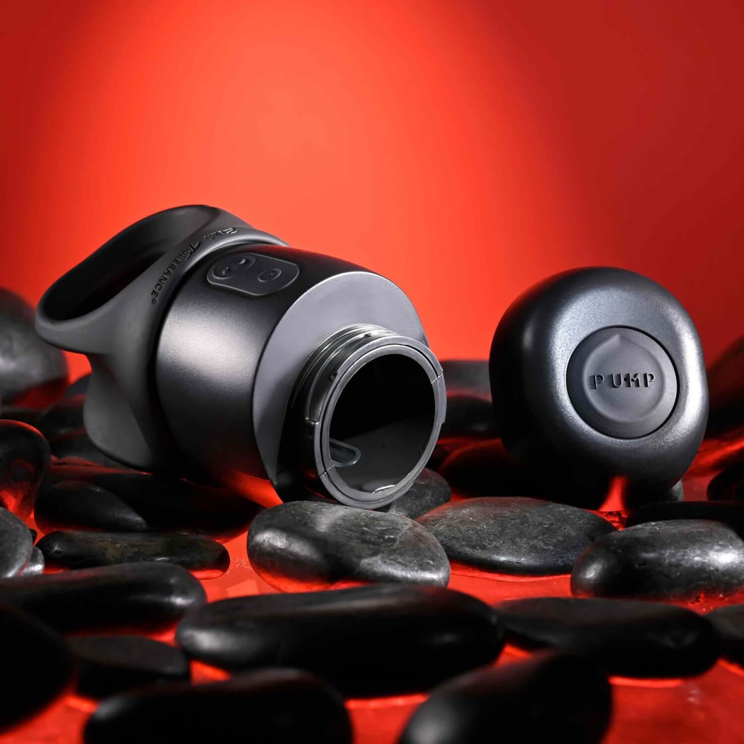 Wet It Be Black USB rechargeable stroker on smooth stones, showcasing ergonomic design and button for lubrication release.