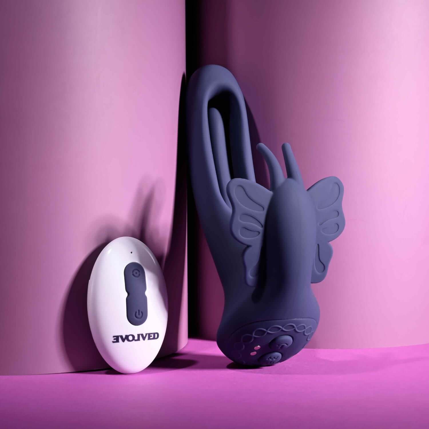 Lord of the Wings remote control flapping vibrator in purple with butterfly stimulator against a pink background.