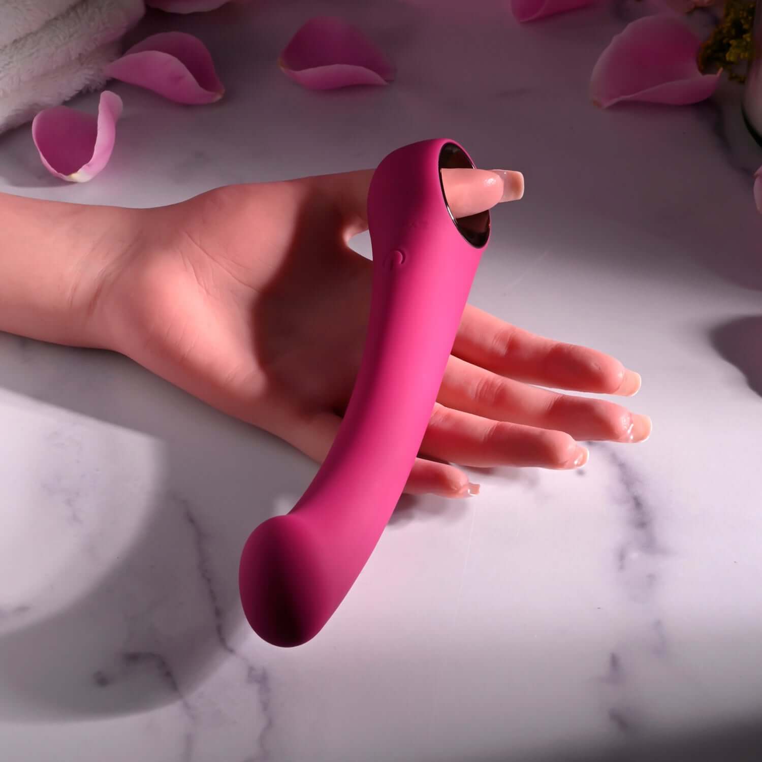 Burgundy Pleasure Curve G-spot vibrator with ergonomic design, resting in a hand surrounded by soft petals.