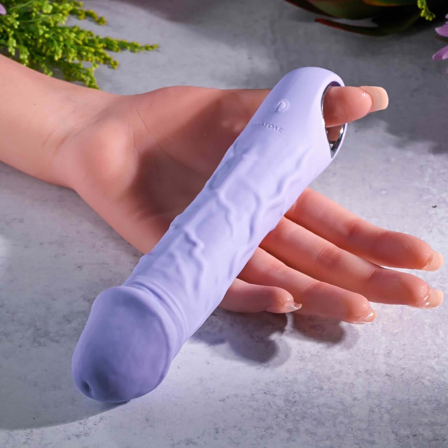 Flexible purple fantasy vibrator with realistic textures, chrome handle, and USB rechargeable feature, held in a hand.