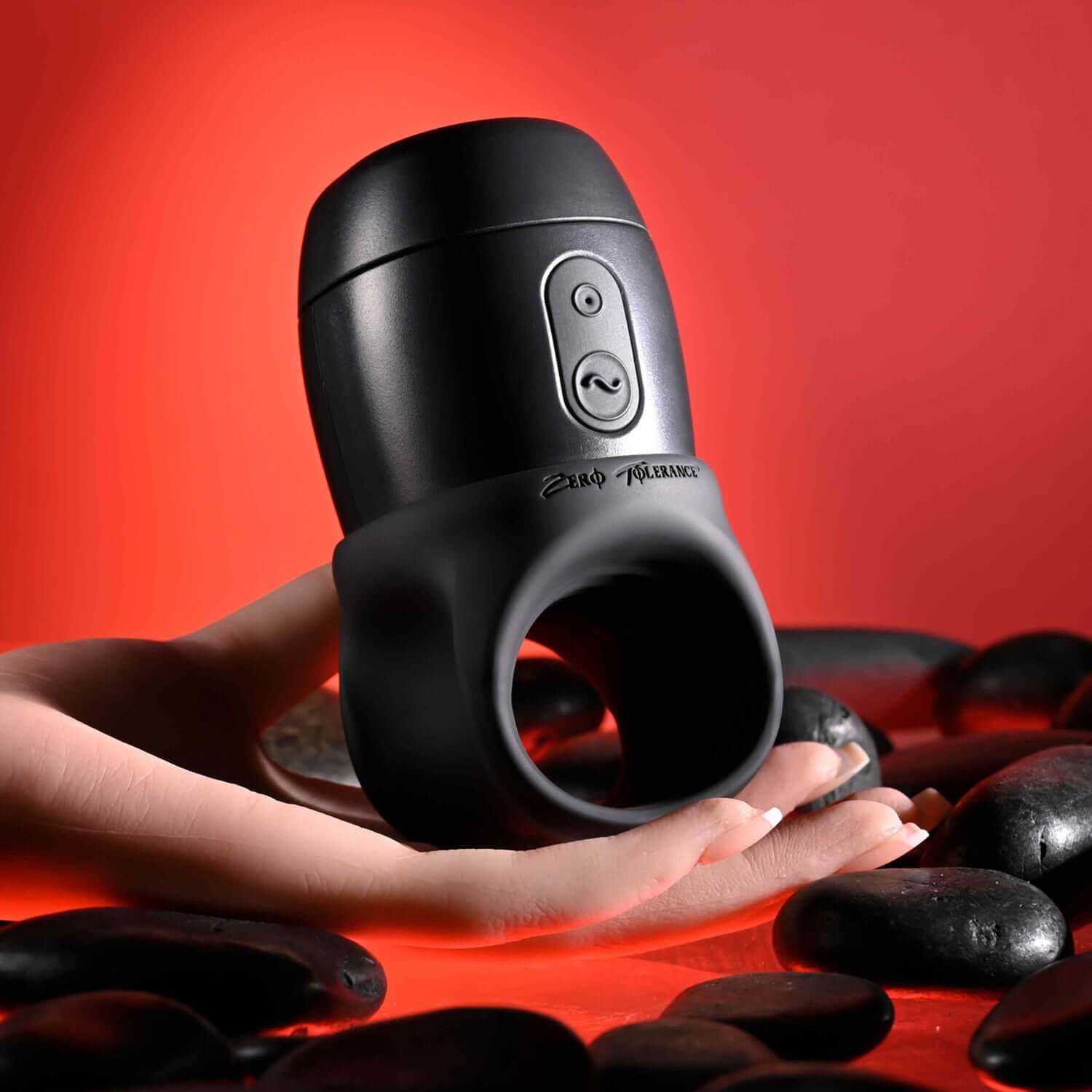 Black USB rechargeable stroker held in hand, featuring ergonomic button and sleek design against a red background.