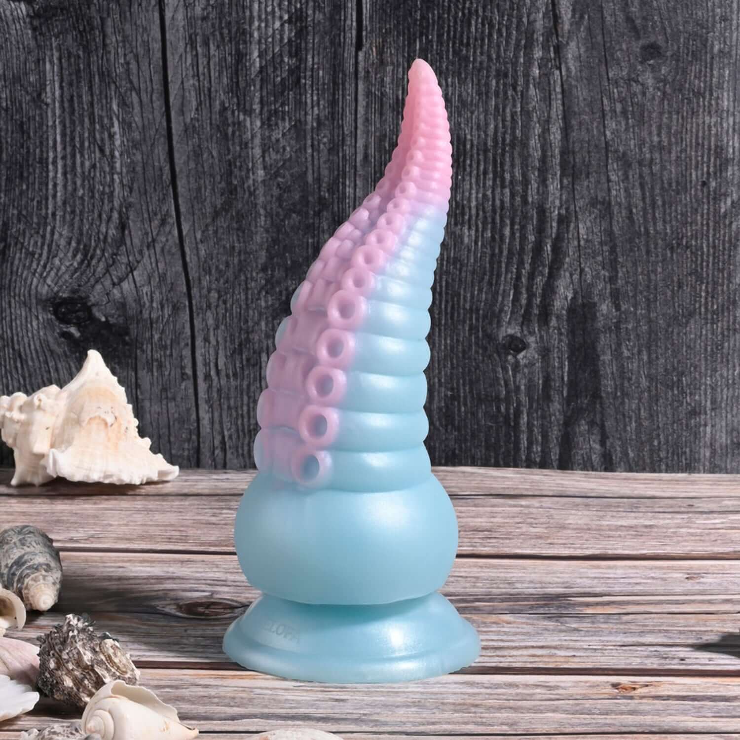 Stuck on You Vibrating Dildo in multicolor, featuring tentacle design and suction cup base, set on a wooden surface.