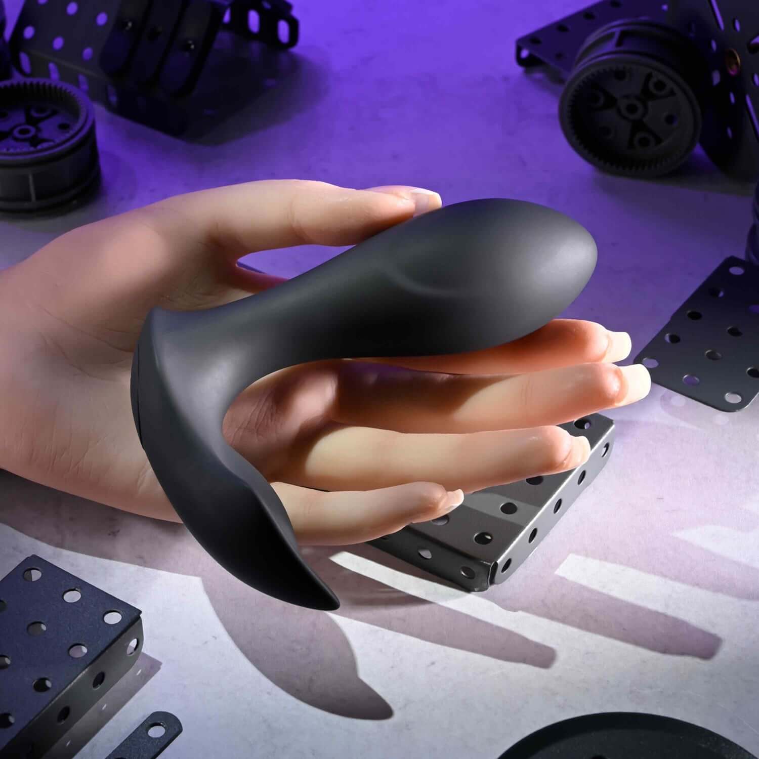 Remote controlled anal massager in a hand, showcasing its discreet design and flexible shape for pleasurable experiences.