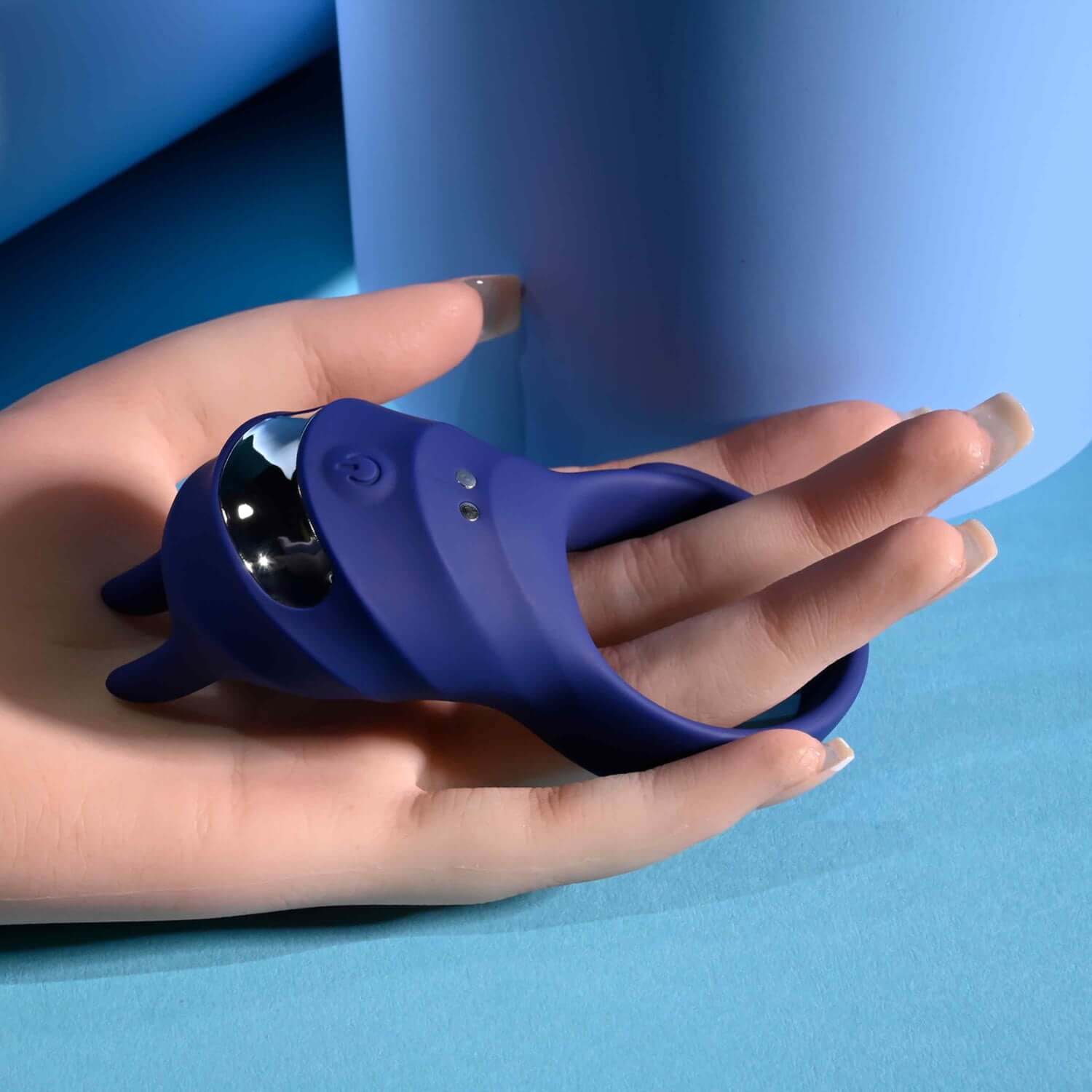 Adjustable blue cock ring held in hand, showcasing its flexible design and modern features for enhanced pleasure.