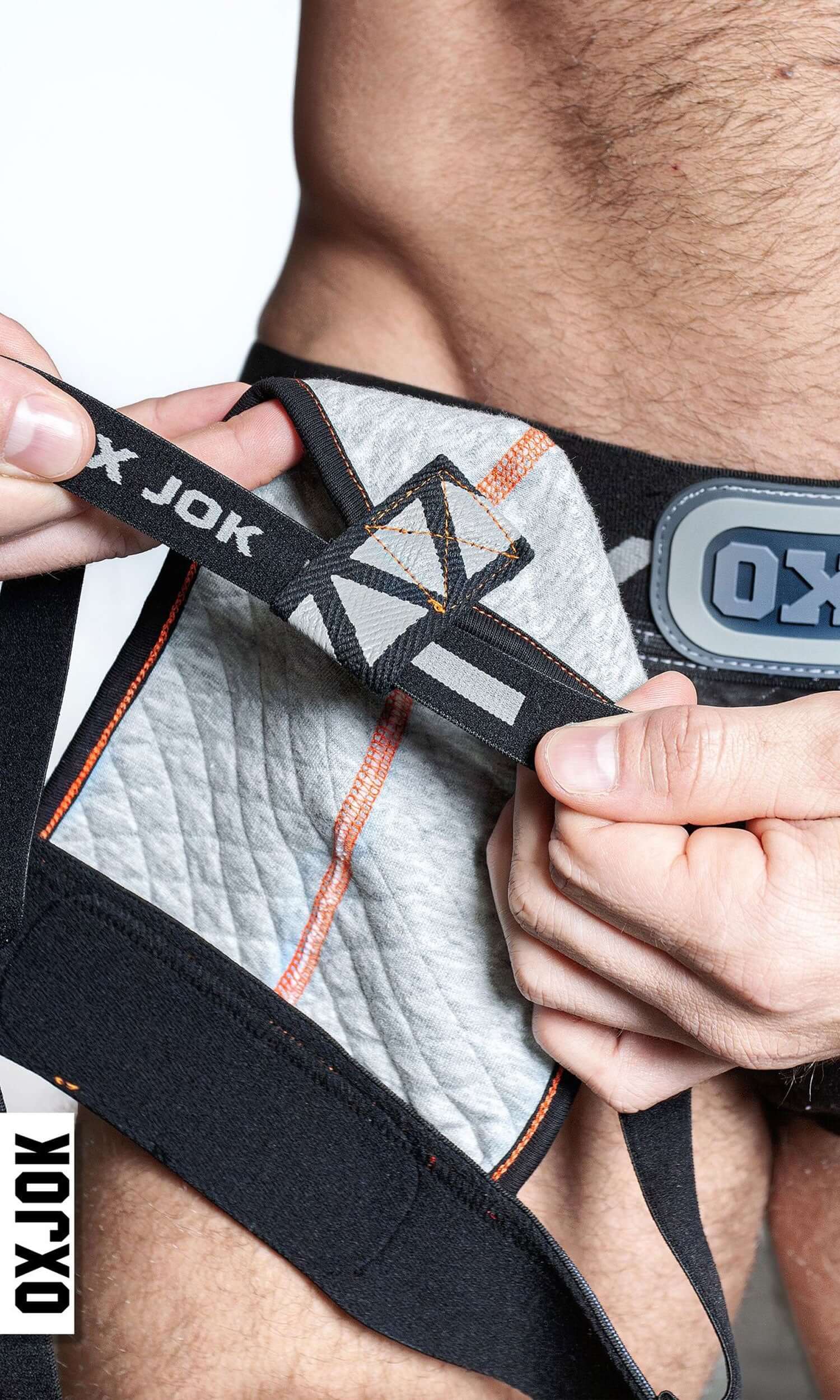 Close-up of Packer Industrial Quilted Cargo Strapjock with hazzard stripe waistband showing oxjock label and detailed pouch design.