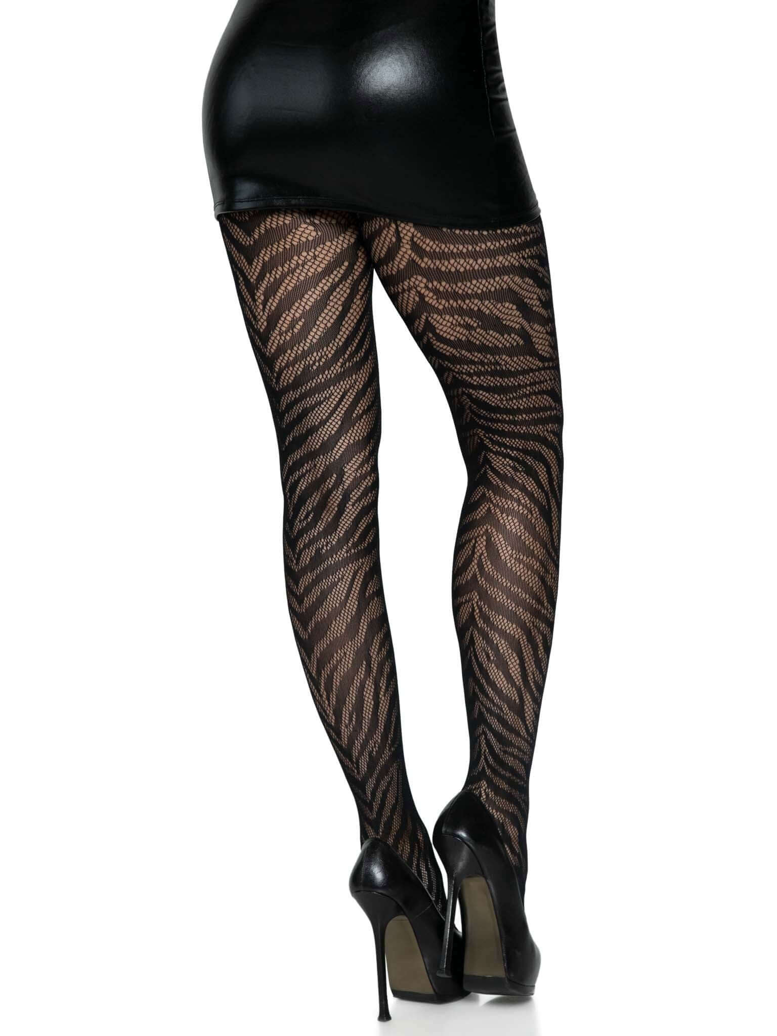 Woman wearing Zebra Net Tights by Leg Avenue in black animal print fishnet with heels and black skirt.